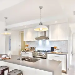 Cuisine moderne avec îlot, évier double et suspension industrielle. Belle idée éclairage cuisine plafond pour une ambiance chaleureuse.