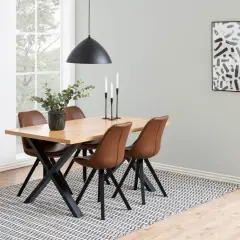Quelles chaises avec table industrielle : un ensemble repas moderne avec des chaises en cuir marron et une table en bois sur des pieds noirs.