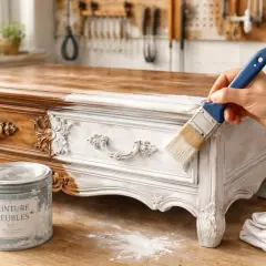 Application de peinture blanche sur un meuble ancien, laissant apparaître le bois brut par endroits. Le poncer et le laisser brut pour un style shabby chic.
