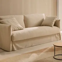 Un canapé beige confortable, des coussins douillets, une plante verte et des tables basses en bois. Quelle déco avec canapé beige pour un salon cosy et lumineux.