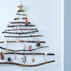Arbre de Noël original à fabriquer soi-même avec des branches de récupération. Décoré de petites figurines et ornements suspendus.