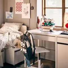 Aménagement petite chambre ado : lit confortable, bureau blanc avec fournitures créatives, et un sac à dos rigolo.