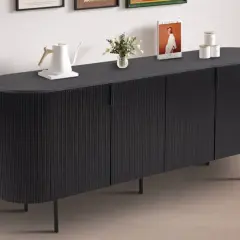 Buffet de salle à manger noir aux lignes verticales, avec une bouilloire blanche, des livres et des pots décoratifs sur le dessus. Ses dimensions s'intègrent parfaitement dans un espace moderne.