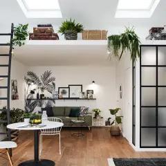 Aménagement intérieur appartement moderne avec mezzanine, échelle noire, mur végétal stylisé, mobilier design et verrière industrielle.