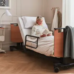 Femme lisant au lit. L'avantage inconvénient lit électrique : confort et autonomie pour elle.