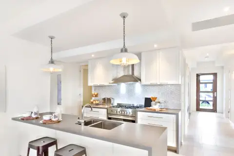 Cuisine moderne avec îlot, évier double et suspension industrielle. Belle idée éclairage cuisine plafond pour une ambiance chaleureuse.