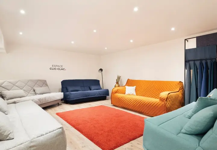 Espace clic clac : plusieurs canapés confortables aux couleurs vives et douces, avec un échantillonnage de tissus.