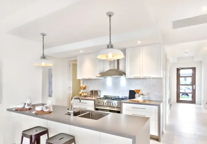 Cuisine moderne avec îlot, évier double et suspension industrielle. Belle idée éclairage cuisine plafond pour une ambiance chaleureuse.