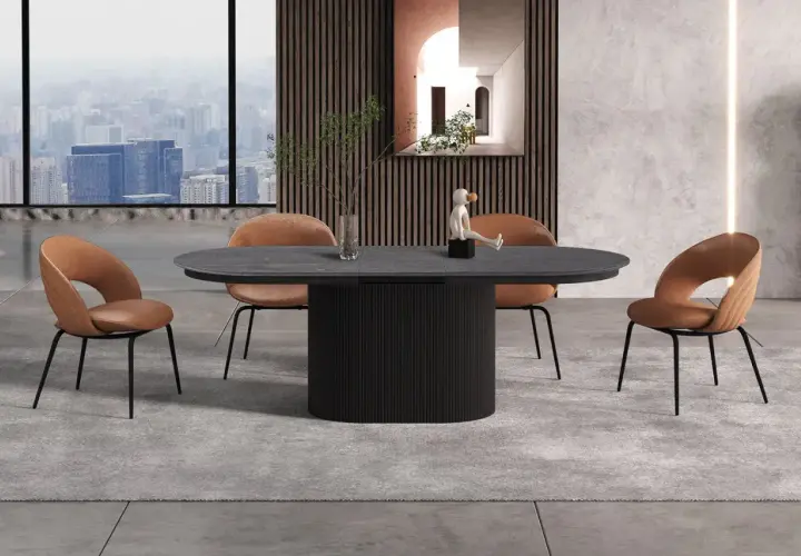 Table 12 personnes dimensions : un plateau ovale en pierre sombre repose sur un pied cylindrique noir. Quatre chaises en velours marron entourent la table.