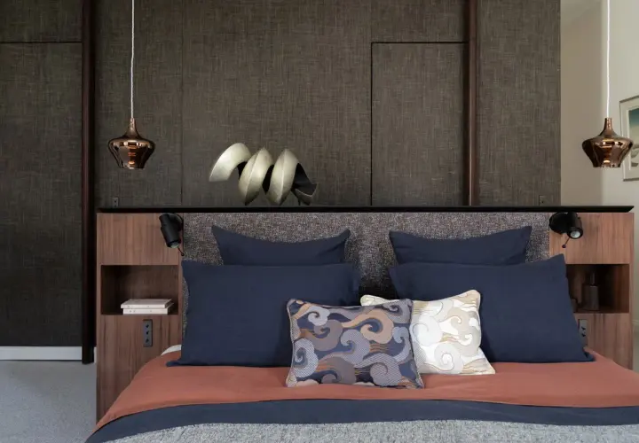 Lit moderne avec tête de lit haute et coussins décoratifs. Quelle hauteur pour une tête de lit ? Celle-ci est bien proportionnée.