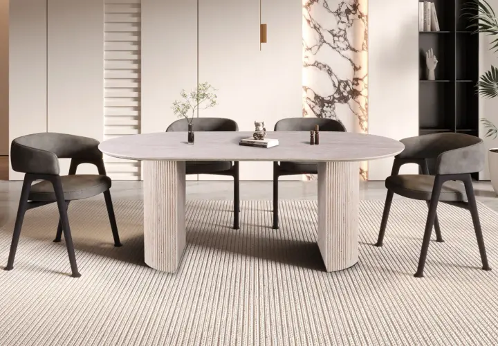 Table ovale moderne pour 8 personnes, aux dimensions généreuses, avec pieds sculpturaux et chaises grises confortables.