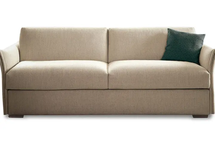 Canapé convertible beige, un coussin vert à motifs. Idéal pour la maison convertible, avis positif garanti.
