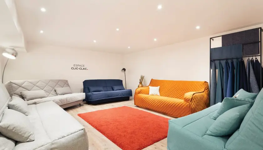 Espace clic clac : plusieurs canapés confortables aux couleurs vives et douces, avec un échantillonnage de tissus.