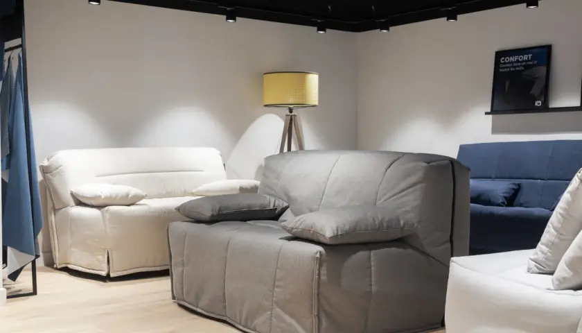 Canapés confortables dans un magasin. Le canapé gris est en position bz, prêt à accueillir des invités.
