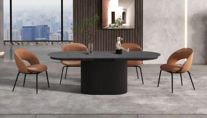 Table 12 personnes dimensions : un plateau ovale en pierre sombre repose sur un pied cylindrique noir. Quatre chaises en velours marron entourent la table.