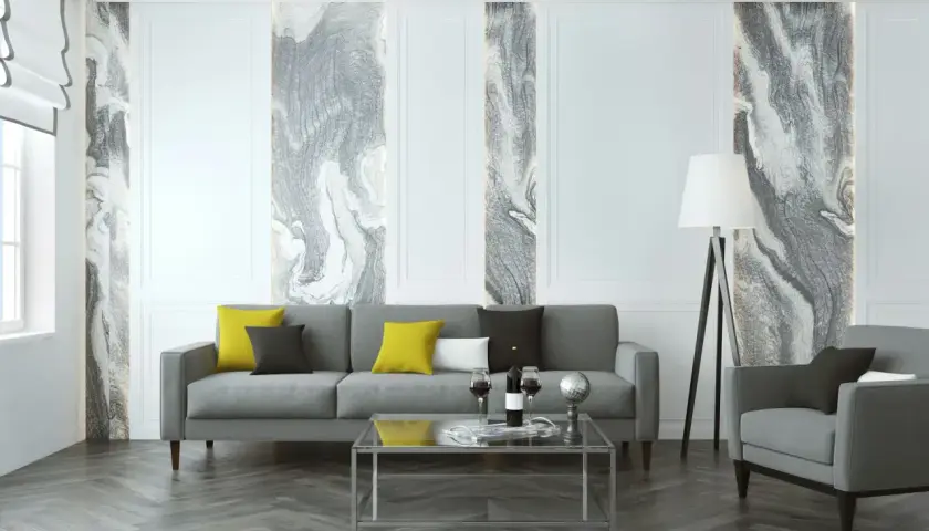 Salon moderne avec canapé gris, coussins colorés et un papier peint écologique aux motifs marbrés abstraits.