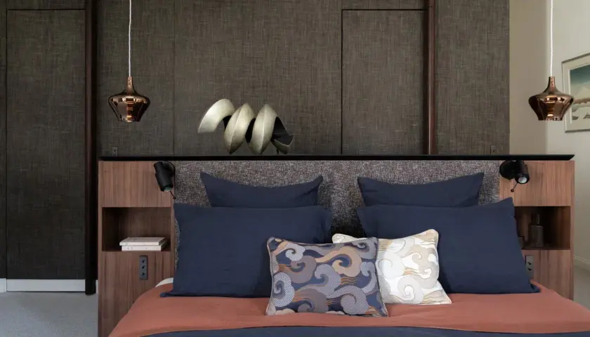 Lit moderne avec tête de lit haute et coussins décoratifs. Quelle hauteur pour une tête de lit ? Celle-ci est bien proportionnée.
