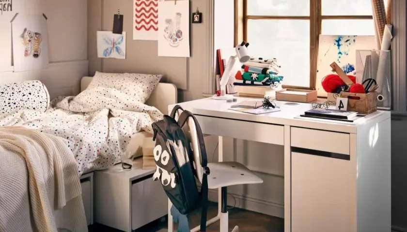 Aménagement petite chambre ado : lit confortable, bureau blanc avec fournitures créatives, et un sac à dos rigolo.