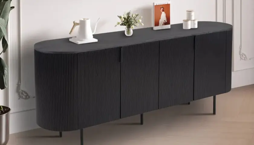 Buffet de salle à manger noir aux lignes verticales, avec une bouilloire blanche, des livres et des pots décoratifs sur le dessus. Ses dimensions s'intègrent parfaitement dans un espace moderne.