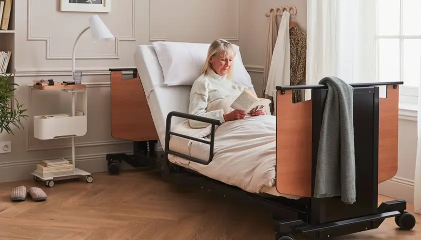 Femme lisant au lit. L'avantage inconvénient lit électrique : confort et autonomie pour elle.