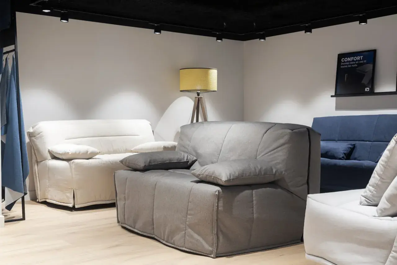 Canapés confortables dans un magasin. Le canapé gris est en position bz, prêt à accueillir des invités.