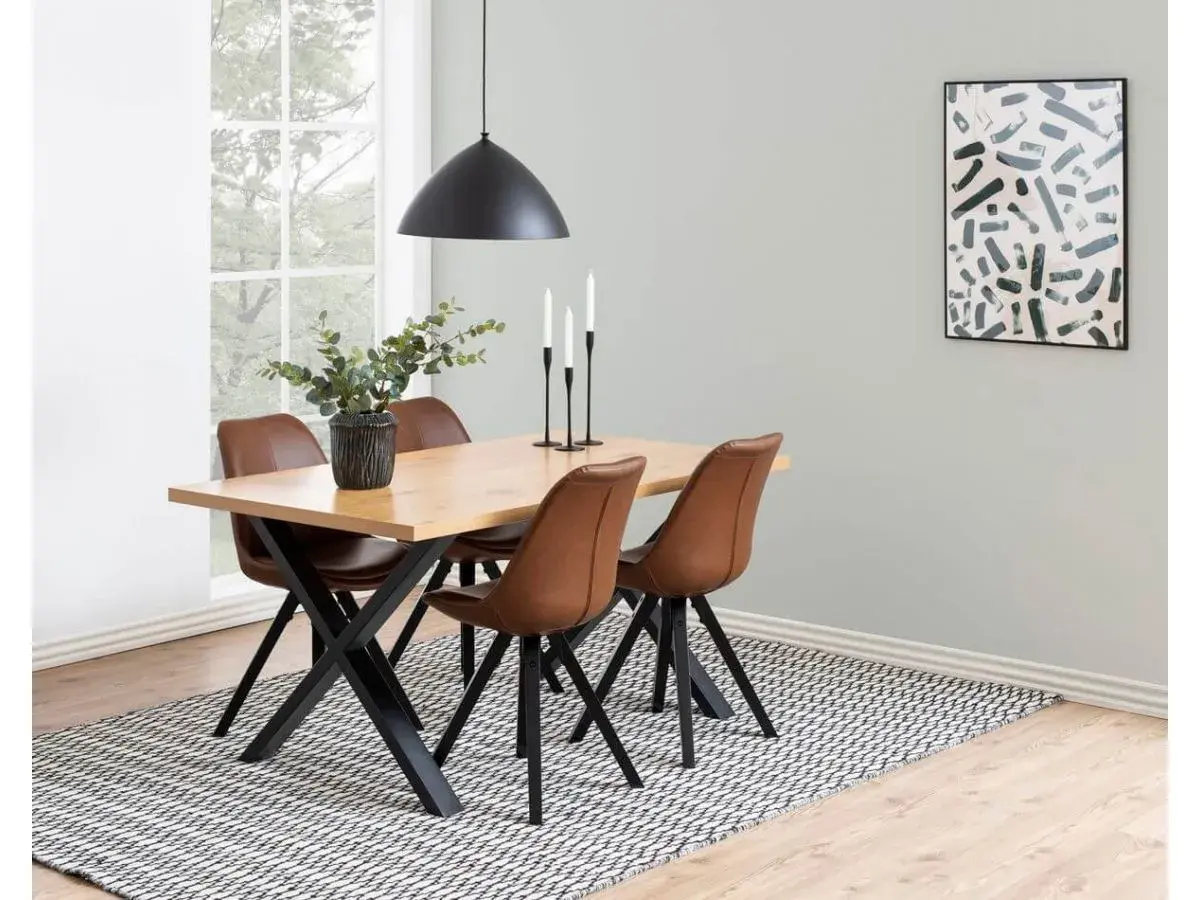 Quelles chaises avec table industrielle : un ensemble repas moderne avec des chaises en cuir marron et une table en bois sur des pieds noirs.