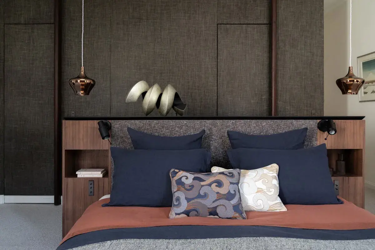 Lit moderne avec tête de lit haute et coussins décoratifs. Quelle hauteur pour une tête de lit ? Celle-ci est bien proportionnée.