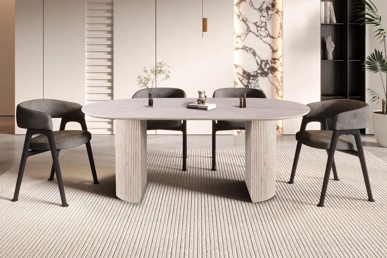 Table ovale moderne pour 8 personnes, aux dimensions généreuses, avec pieds sculpturaux et chaises grises confortables.