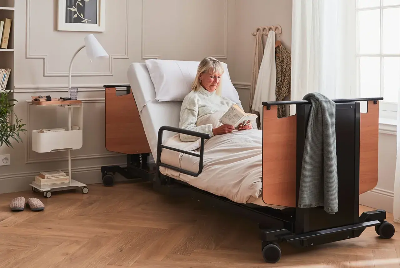 Femme lisant au lit. L'avantage inconvénient lit électrique : confort et autonomie pour elle.