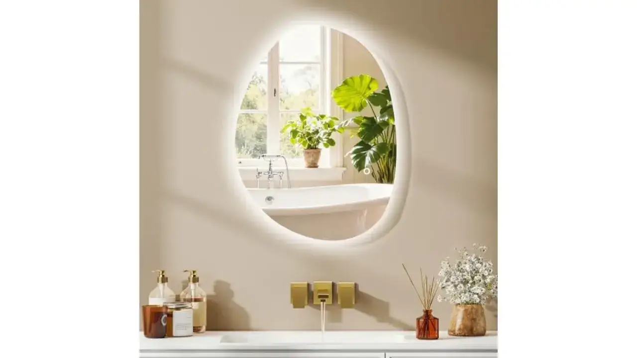 Miroir ovale lumineux refl&eacute;tant une baignoire et des plantes, une id&eacute;e pour comment rendre une pi&egrave;ce plus lumineuse.