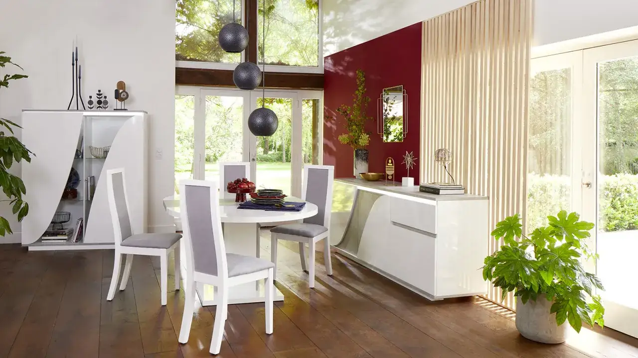 Une &eacute;l&eacute;gante etagere sejour blanche, avec des chaises grises autour d'une table ronde. Un buffet bas et une plante verte compl&egrave;tent la sc&egrave;ne.