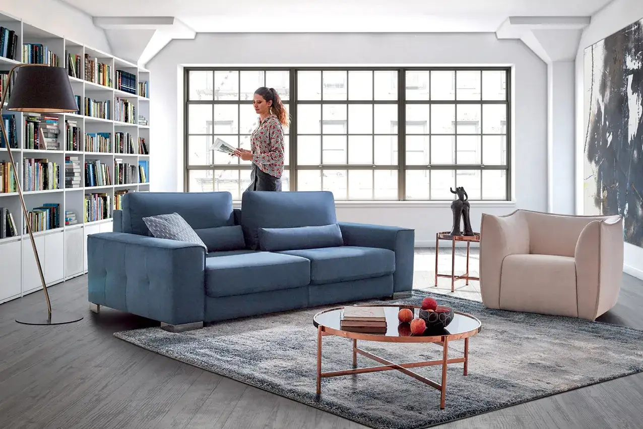 Un salon moderne avec un canap&eacute; bleu, un fauteuil beige et une table basse. Quel est le meilleur tissu pour canap&eacute; ? Ce velours semble doux et confortable.