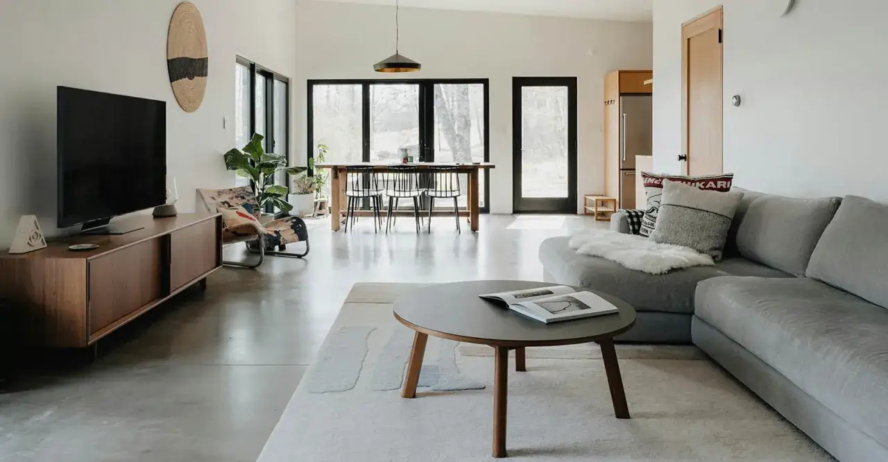Un salon moderne avec une TV, un canapé confortable et une table basse. La distance entre la TV et le canapé semble parfaite pour regarder un film.