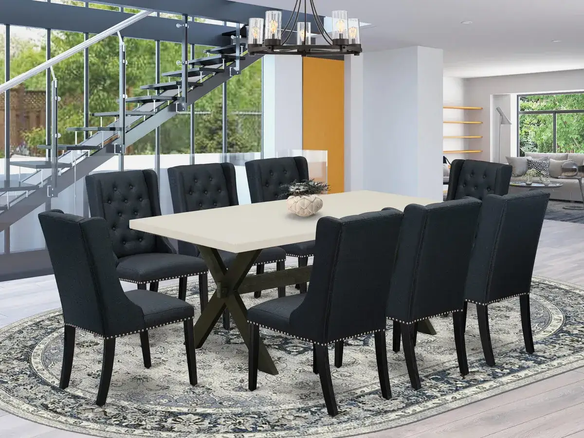 Comment assortir des chaises à une table : chaises sombres capitonnées autour d'une table claire, dans un salon moderne avec escalier.