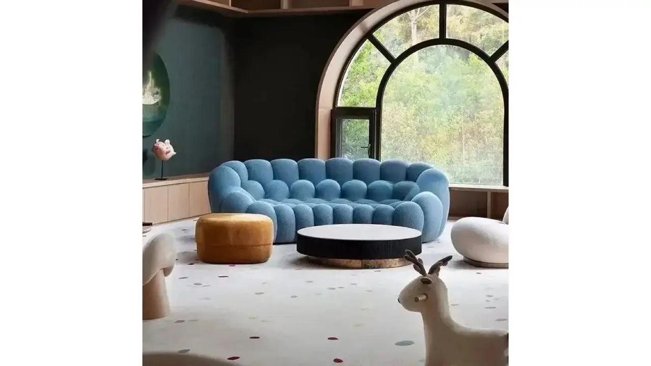 Quel canapé quand on a un chat ! Ce salon moderne avec son canapé bleu bouffant, pouf orange et tapis ludique invite à la détente.