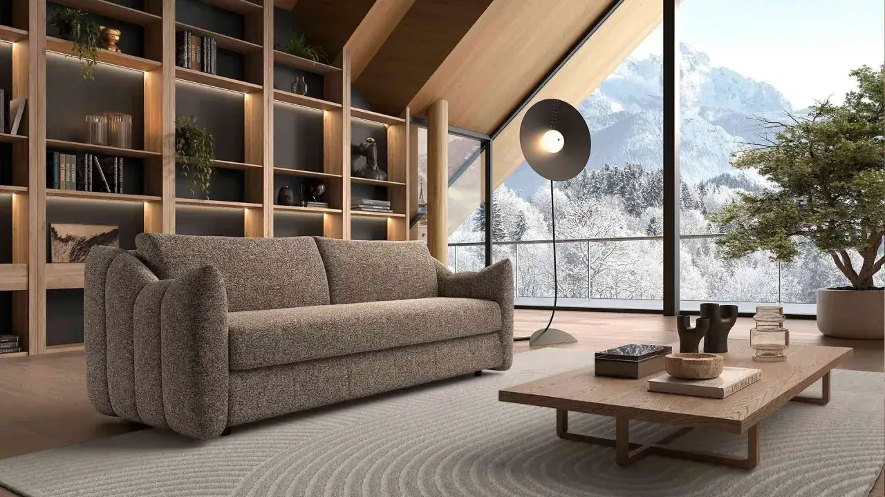 Canap&eacute; confortable dans un salon moderne avec vue sur la montagne enneig&eacute;e. Avis sur la maison convertible.