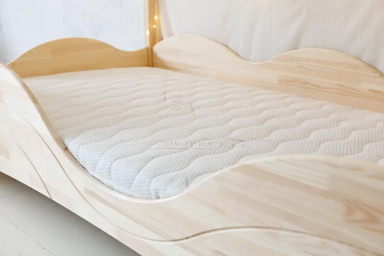 Un lit en bois clair avec un matelas mousse et latex, pr&ecirc;t pour de douces nuits.