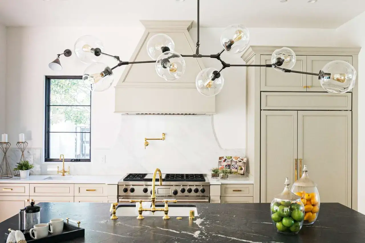 Une belle idée d'éclairage cuisine plafond : un lustre moderne avec des globes en verre et des ampoules Edison, au-dessus d'un îlot de cuisine.