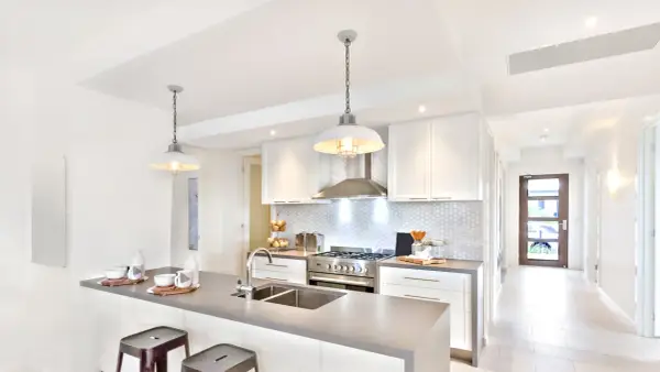 Cuisine moderne avec îlot, évier double et suspension industrielle. Belle idée éclairage cuisine plafond pour une ambiance chaleureuse.